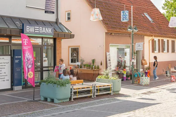 Temporäre Sitzmöbel und Pflanzkübel vor Geschäften in der gesperrten Buhlstraße in Weinstadt-Beutelsbach während der Aktion „Ab in die Mitte“