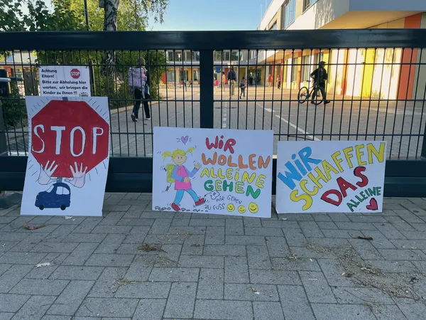 Selbst gemalte Schilder am Schulzaun mit den Aufschriften „Stop", „Wir wollen alleine gehen" und „Wir schaffen das alleine".